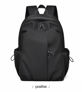 Front view of black minimalist backpack showing geometric fold and knotted zipper pulls
