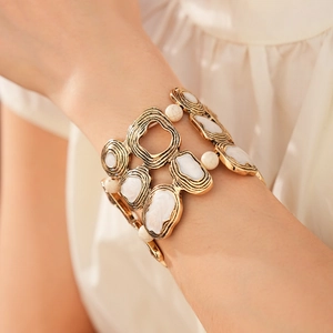 Detail of vintage geometric open bangle with gold metal finish and marble resin inlays