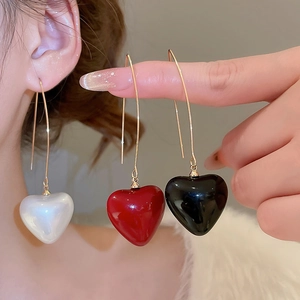 Detail showing pearl heart pendants in white, red and black with gold hooks