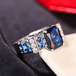 Macro shot of rectangular blue gemstone ring with intricate micro-pave diamond setting