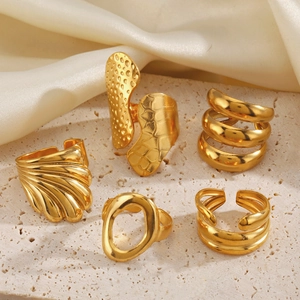 Set of five chunky geometric gold stainless steel rings on premium satin background