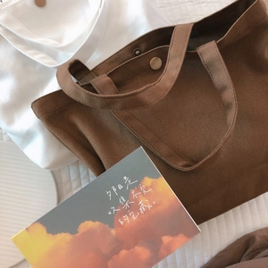 Minimalist canvas tote bags in brown and white with metallic snap closure and textured fabric
