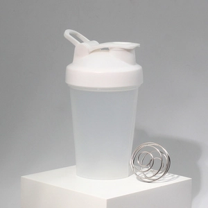 Detail of transparent protein shaker bottle with white flip cap and metal wire mixing ball