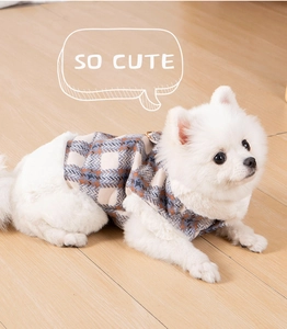 Close-up of checkered dog vest featuring plush trim and metal leash D-ring detail