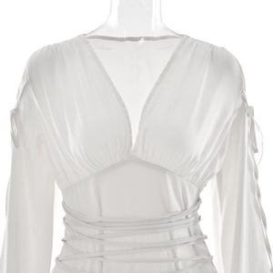Détail du haut en satin blanc à manches longues avec col en V profond et lien à nouer