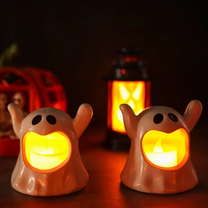 Set of two white ceramic LED ghost lamps creating warm Halloween decorative lighting