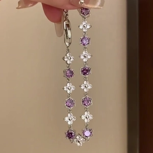 Detail view of silver floral bracelet with purple stones and clover accents