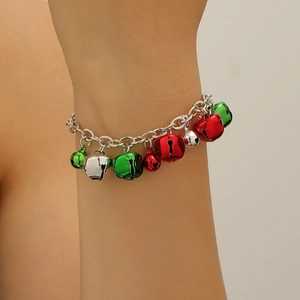 Close-up of a silver festive bracelet with red, green, and silver bells on a wrist