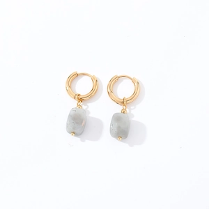 Detail of geometric earrings with golden rings and irregular grey marble stone pendants
