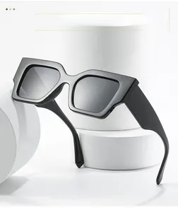 Detailed view of black oversized square sunglasses on a white geometric stand