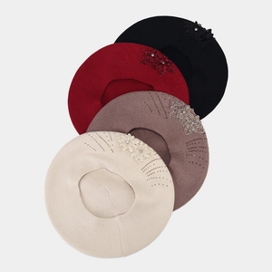 Detail of knitted berets in four colors with floral embroidery and sparkling rhinestones