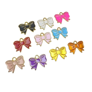 Colorful enamel bow charms for DIY jewelry making displayed on a white background