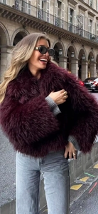 Close-up detail of luxurious dark red faux fur coat showing soft texture and premium quality