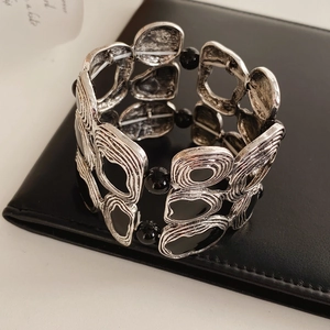 Macro detail of vintage geometric elastic bracelet with silver alloy and black resin