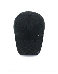 Close-up of winter wool baseball cap featuring herringbone texture and metal logo detail