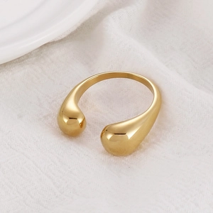 Macro detail of golden open ring featuring two teardrop shapes and high polish finish