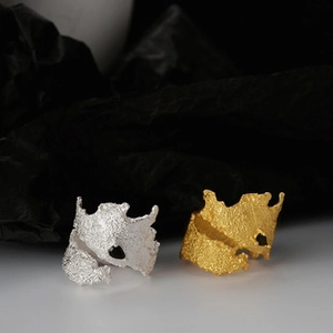 Macro shot of silver and gold wide rings with textured melted metal and hollow design