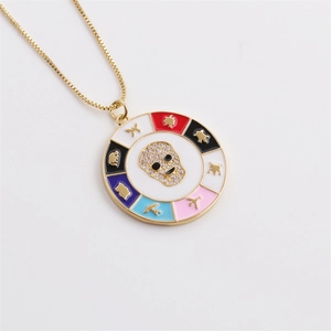 Detail of gold box chain necklace with colorful enamel skull pendant and micro zircons
