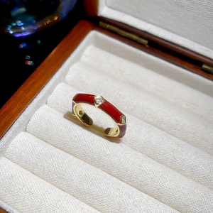 Detail of 14k gold plated ring featuring red enamel and square zircon accents