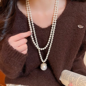 Close-up of elegant double-layer pearl necklace with a large gold-capped pearl pendant