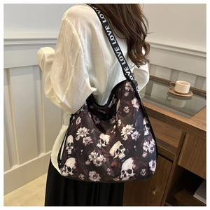 Detail of nylon crossbody bag featuring skull floral prints and LOVE lettered strap
