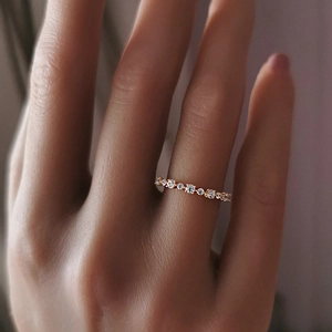 Primo piano dettagliato di un sottile anello in argento 925 placcato oro con zirconi al dito