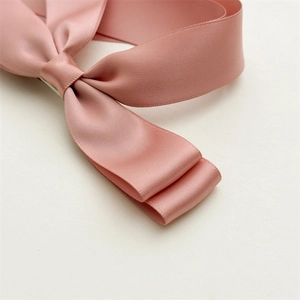 Detailed macro view of the premium pink satin double-layered bow hair clip texture