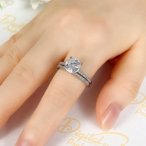 Detailed view of silver stacking ring set featuring a round-cut main stone on a female hand