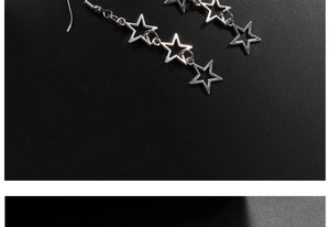 Detail of silver hollow star earrings with three connected stars on black background