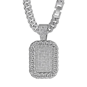 Close-up of silver-tone iced-out Cuban link chain and rhinestone encrusted dog tag pendant