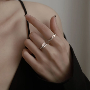Macro view of silver geometric criss-cross rings with sparkling pavé zircons on model hand