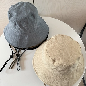 Detail of blue and beige sun hats with water-ripple texture and adjustable wind ropes