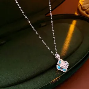 French vintage rhombus flower pendant necklace with pearls and blue zircons on green velvet