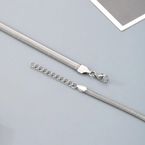 Close-up of a silver flat snake chain necklace with lobster clasp and extension link