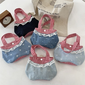 Détail de sacs en denim avec bordure en dentelle et anses à carreaux rouges et bleus