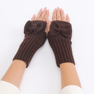 Detail of coffee brown knit fingerless gloves featuring vertical ribbed texture and bow decor