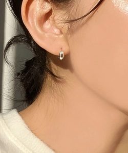 Close-up of minimalist 925 sterling silver oval hoop earrings worn by a model