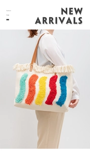 Dettaglio delle strisce colorate e frange su una borsa tote in tela con manico in pelle