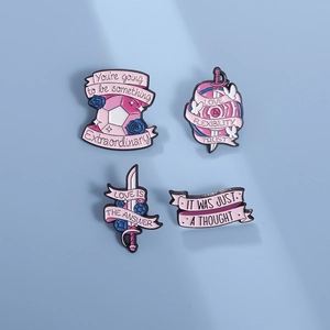 Pink and blue enamel lapel pins with inspirational quotes on a light blue background