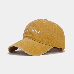 Dettaglio del ricamo Stay Wild su berretto in cotone lavato giallo senape