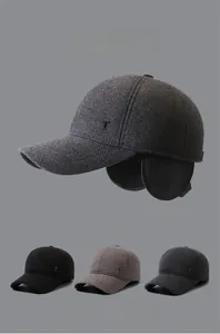 Detail view of winter baseball cap with foldable ear flaps and metal letter T ornament