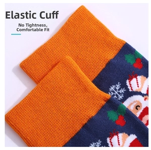 Dettaglio del bordo elastico arancione a coste sulle calze di Natale blu con Babbo Natale