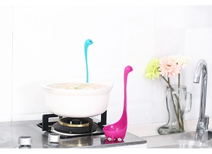 Loch Ness monster soeplepels in blauw en roze staand in een keukenomgeving