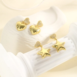 Elegant gold heart and star earrings with zircon inlay on a minimalist pedestal