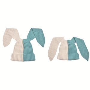 Close-up of ribbed knit texture and long wavy bunny ears on beige and blue beanies