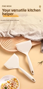 Gros plan d'un ensemble de deux spatules en silicone blanc crème pour poêles antiadhésives