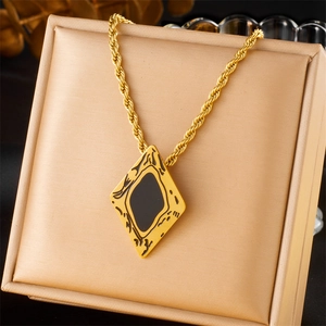 Detail of a gold-plated stainless steel twisted chain necklace with a black rhombus pendant