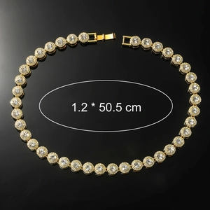 Detail view of gold iced-out tennis necklace with dimensions 1.2 x 50.5 cm on black surface