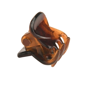 Close-up of small amber tortoiseshell claw hair clip with metal spring on white background