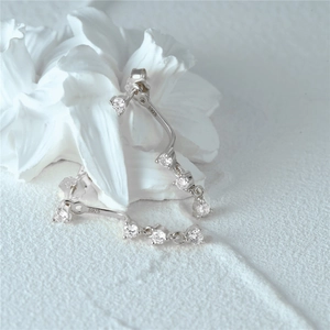 Macro shot of S925 sterling silver earrings with cubic zirconia and minimalist curve detail